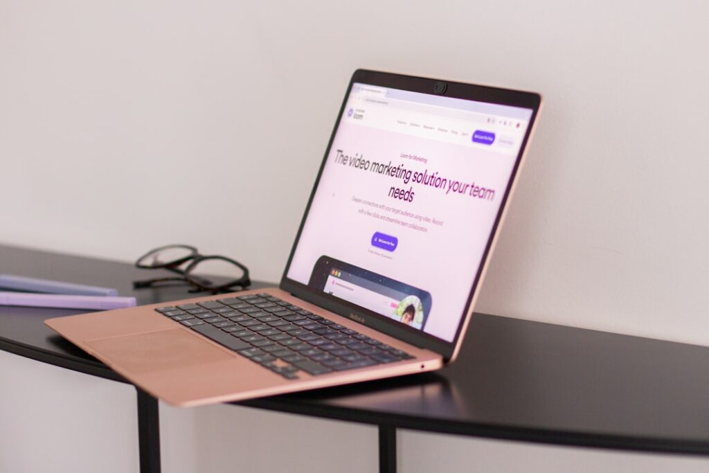 A laptop computer sitting on top of a wooden desk