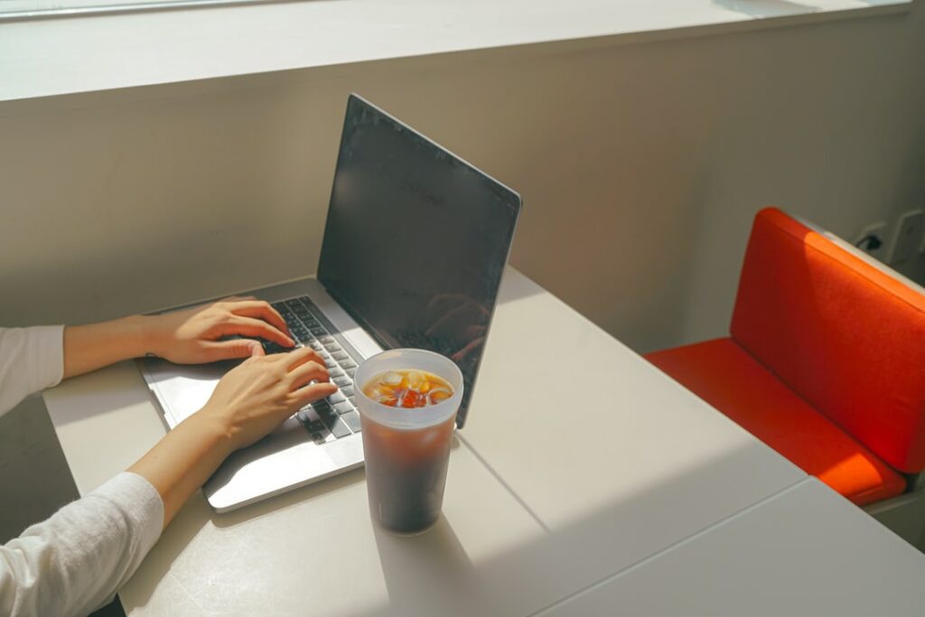 a woman sitting at a table using a laptop computer
