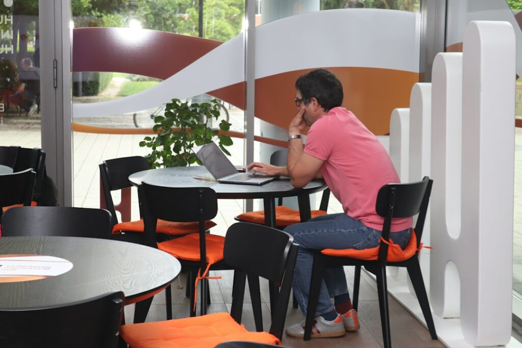 A man sitting at a table using a laptop computer